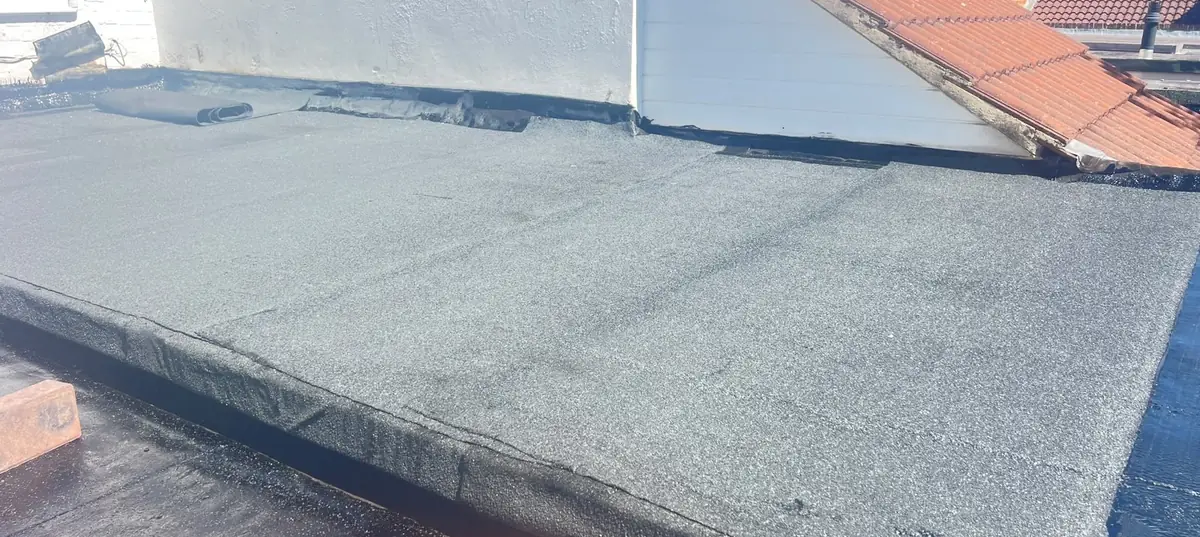 Finished torch-on felt flat roof dressed up to a rendered wall